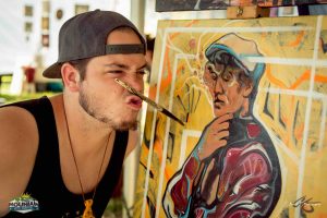 painter with brush on lips at mountain music festival 2017 at ace adventure resort