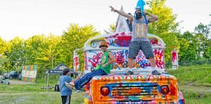Festival fans dance on the painted bus to live music at Mountain Music Festival at ACE Adventure Resort in West Virginia.