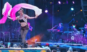 girl dancing with flag in front of main stage at mountain music festival 2019 Ace adventure resort west virginia music festival