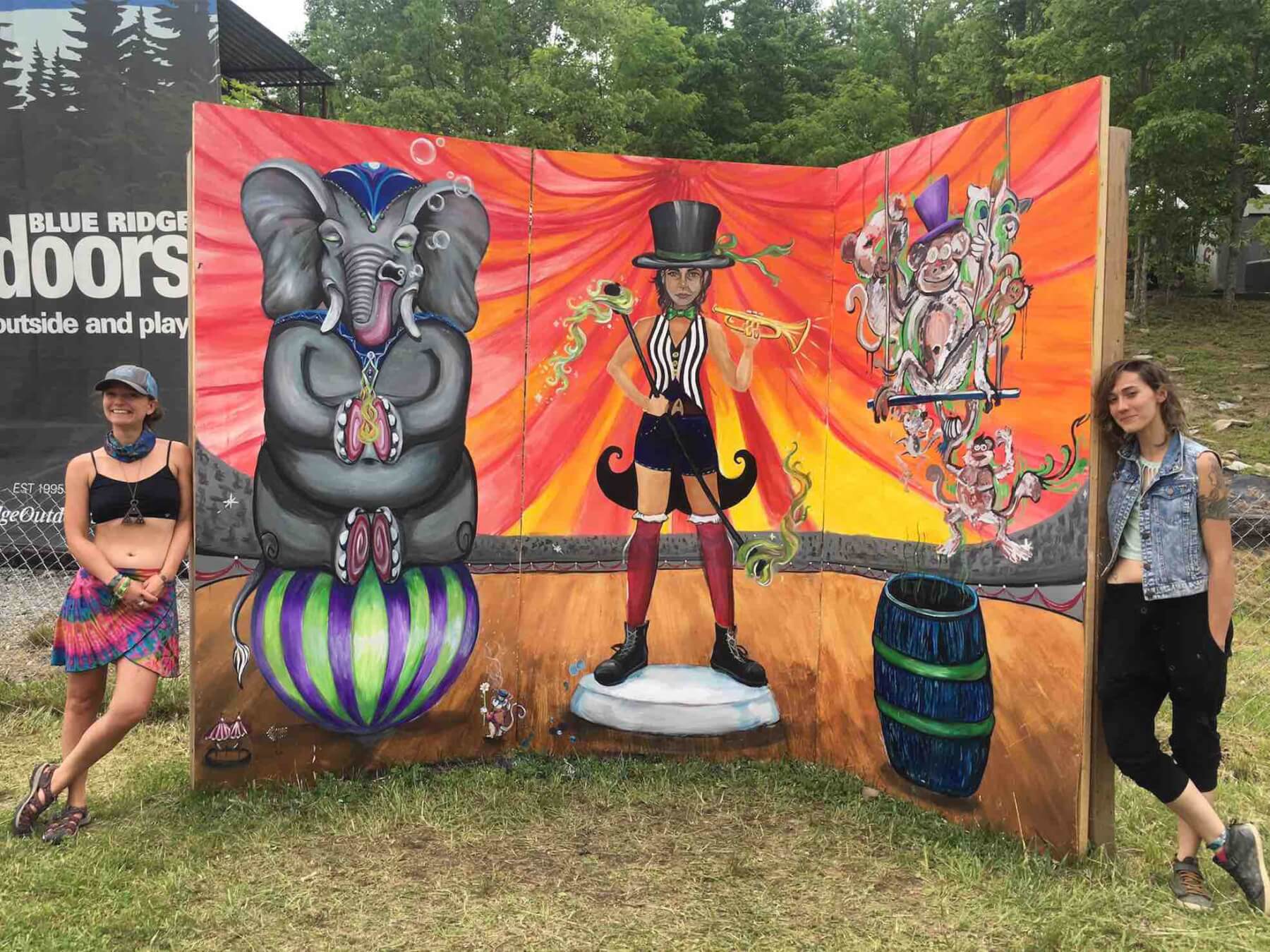 mural created by visual artist team at mountain music festival 2019 with ashton hill and leslie caneda standing next to it