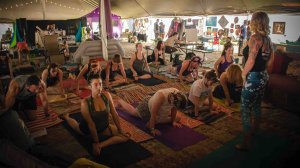festivalgoers doing yoga with candace evans at mountain music festival 2019 in the pigment sanctuary visual artist lounge