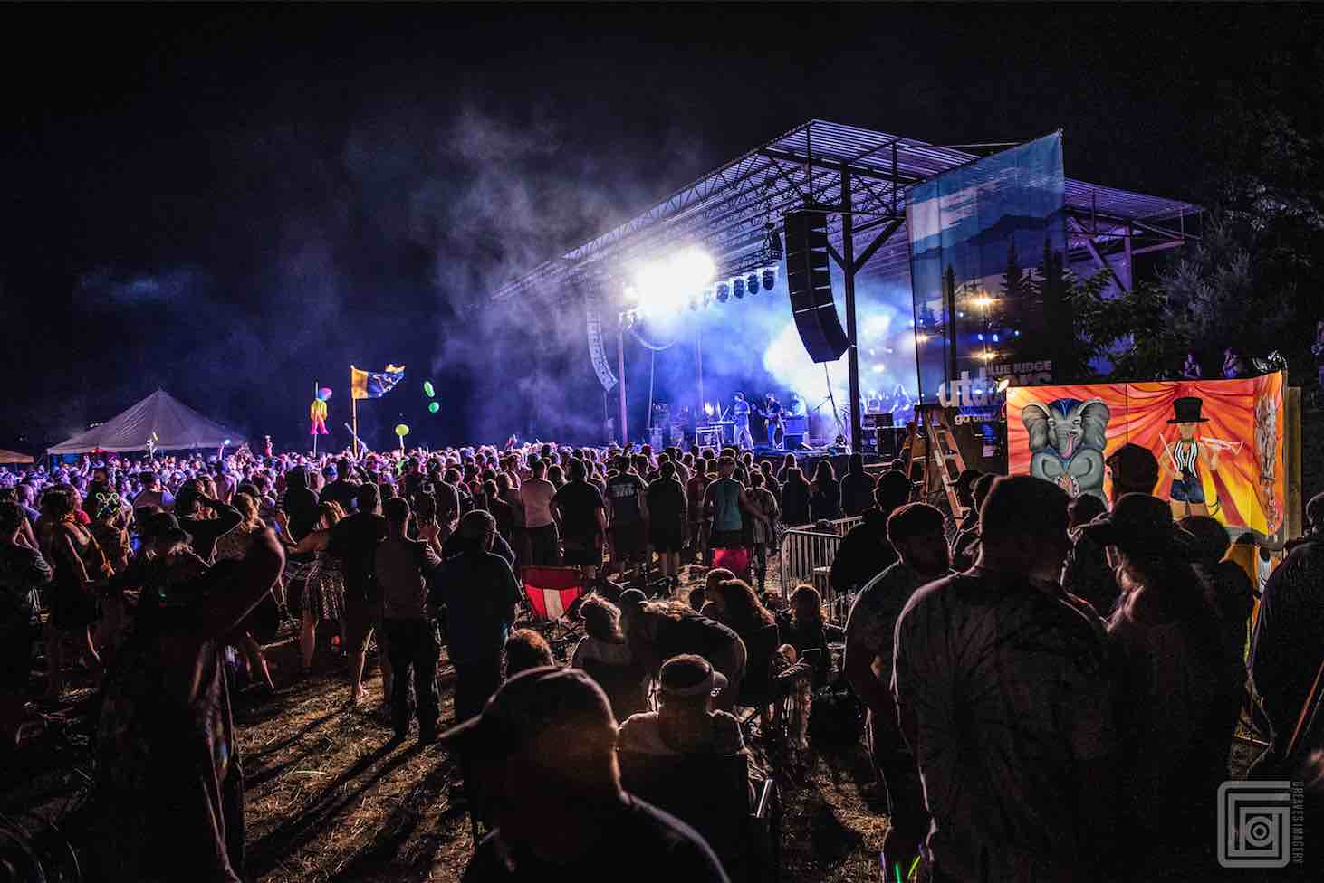 crowd in front of the stage at mountain music festival with artist mural