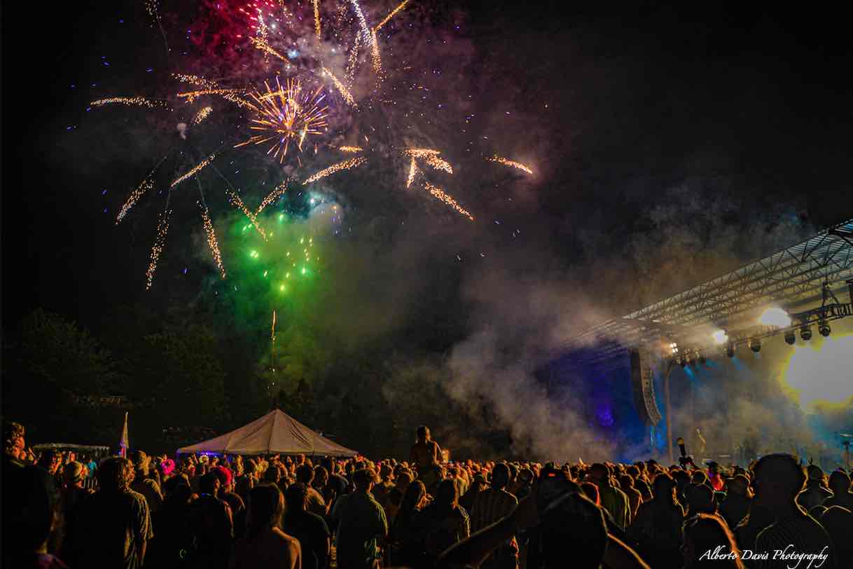 mountain music festival stage and crowd with fireworks