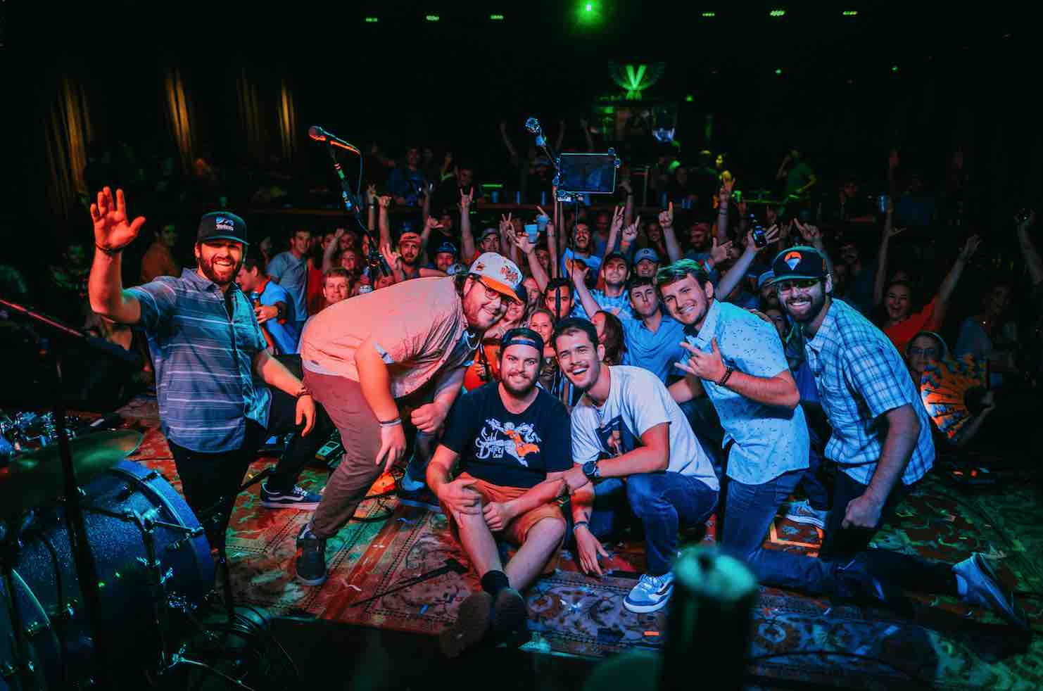 pluto gang posing on stage after a show