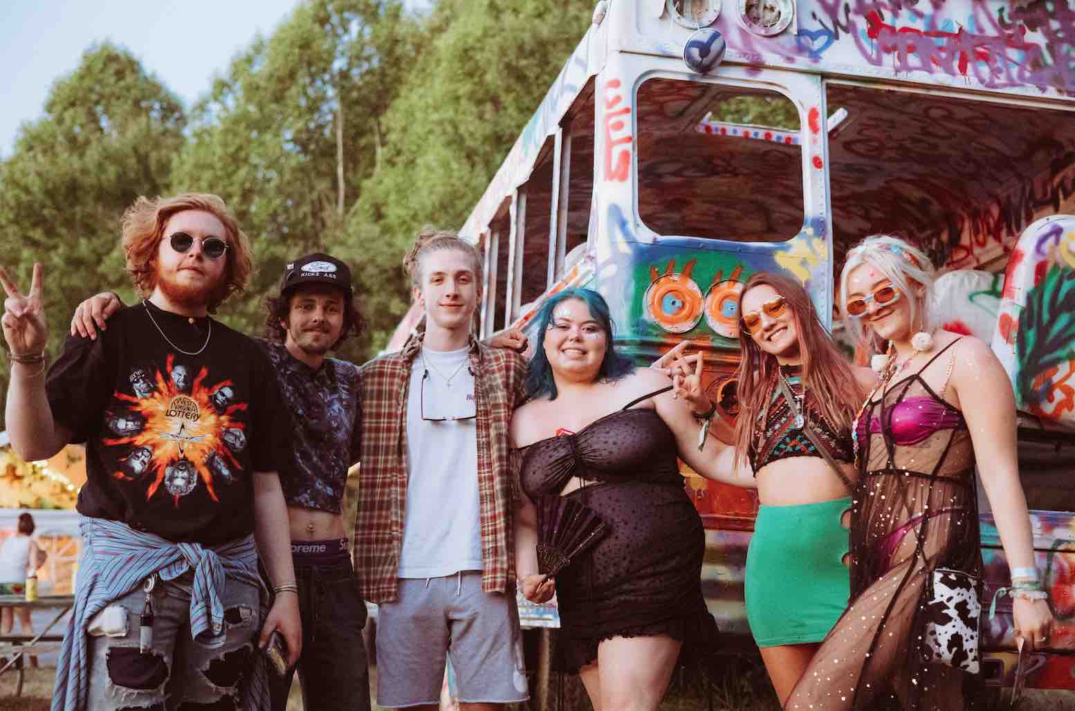 Happy people by the graffitti bus during mountain music festival