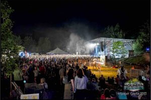 stage at mountain music festival 2021 with crowd and fire performers