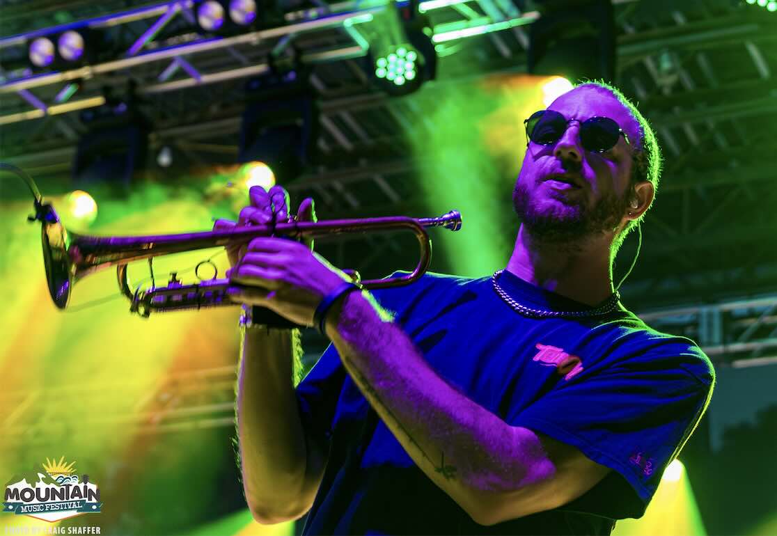 tropidelic band member playing trumpet at mountain music festival 2026